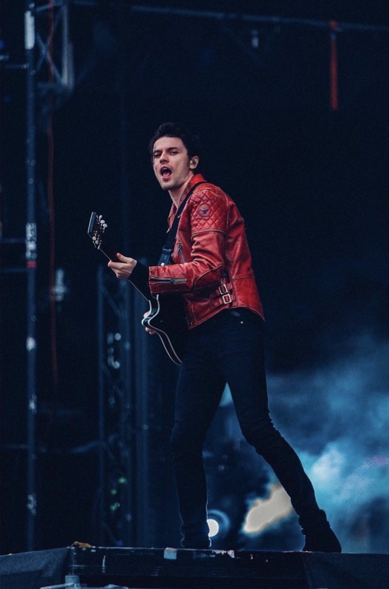Guitarist in a red jacket on a festival stage