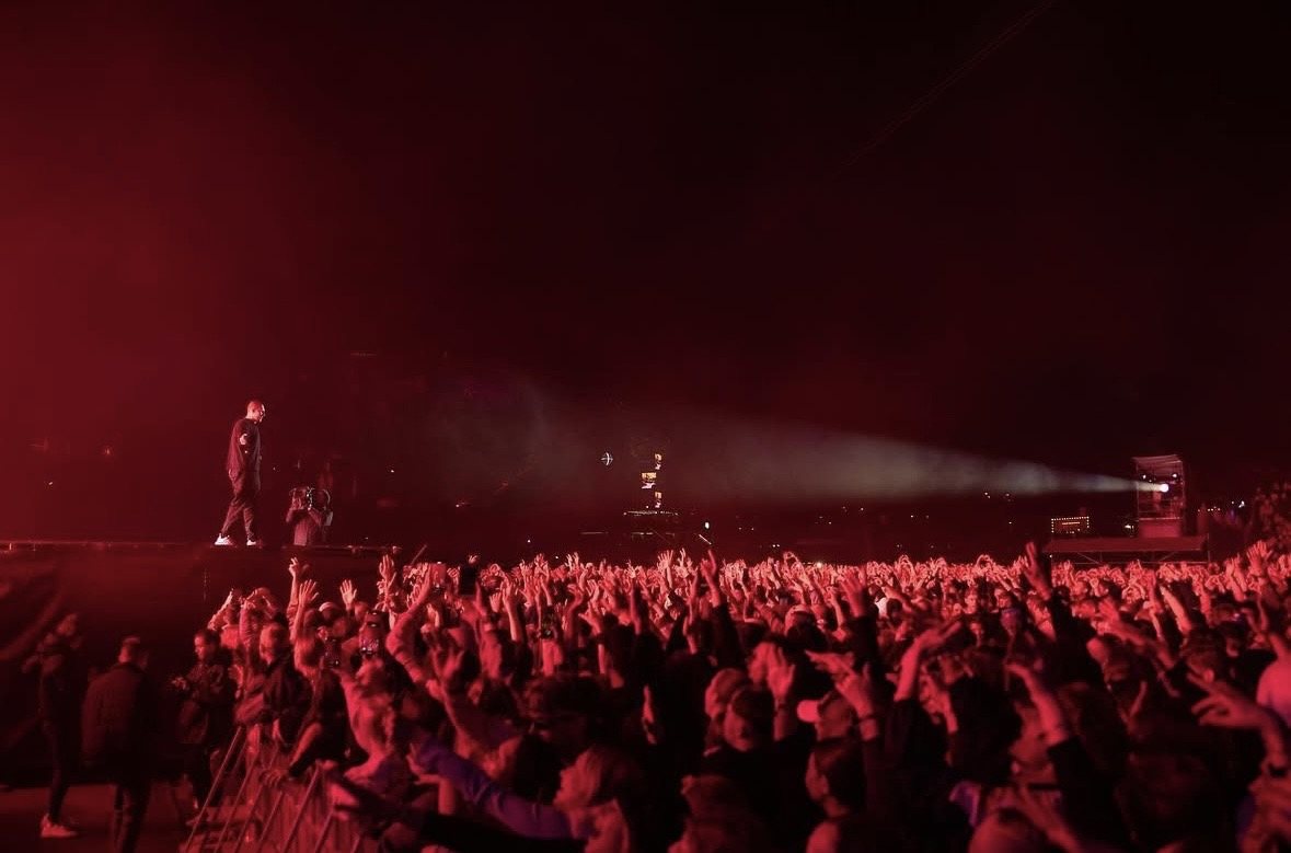 Festival crowd bathed in red light in front of the main stage